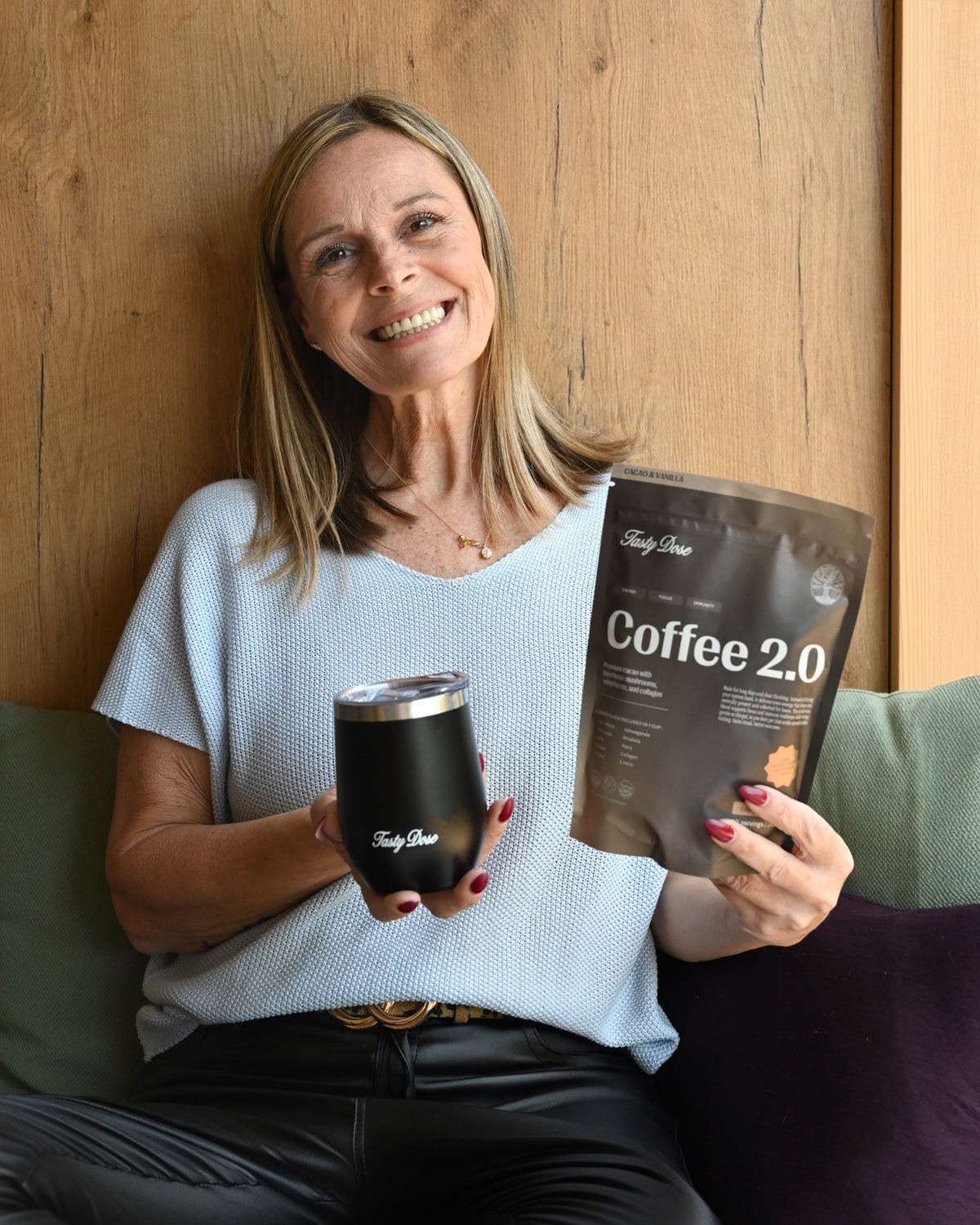 Real Tasty Dose customer smiling with her Coffee 2.0 pouch and tumbler